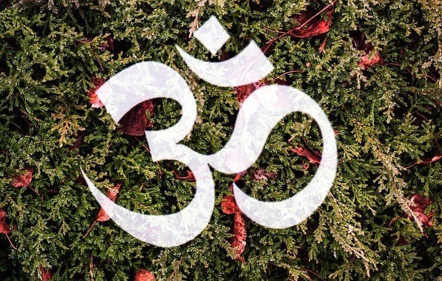 White Om on the background of trees